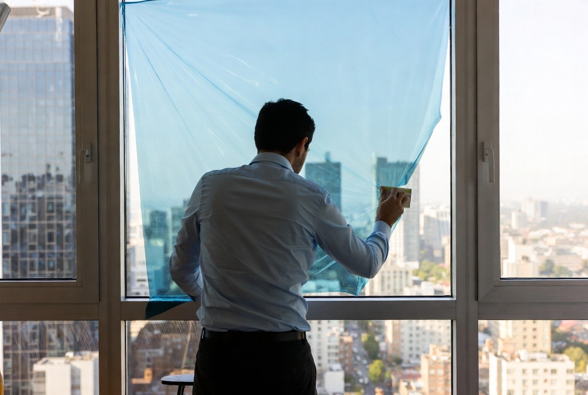 person-installing-window-film-on-glass